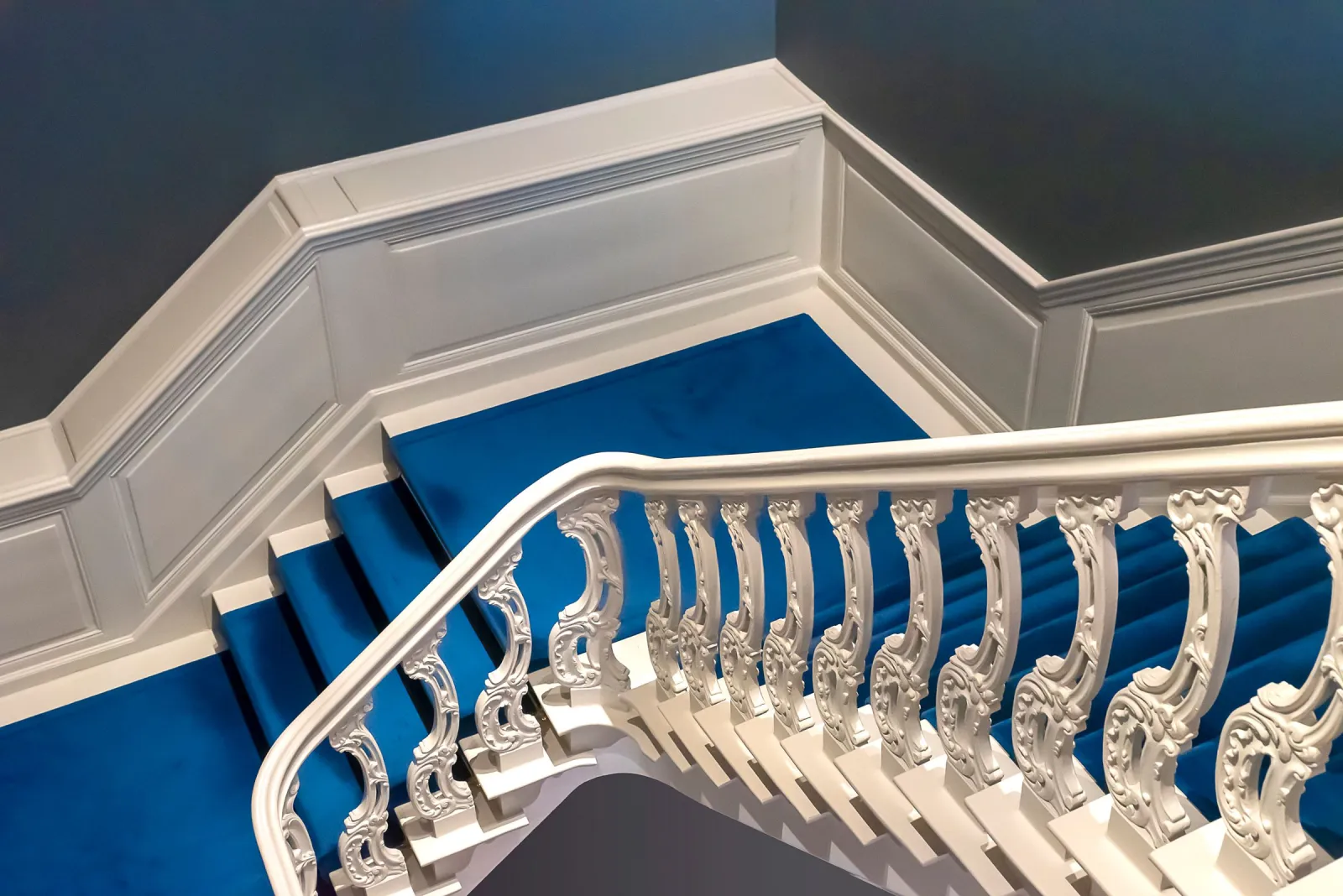 Detailed white staircase with refinished hardwood treads