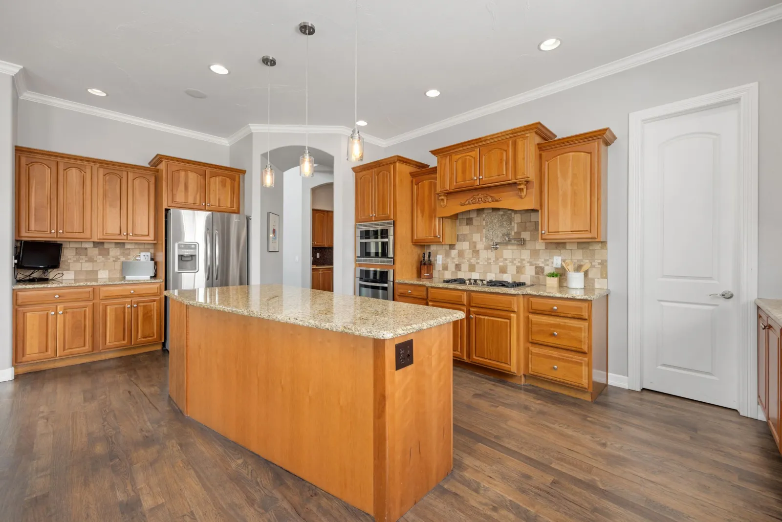 Wood flooring around a granite kitchen island