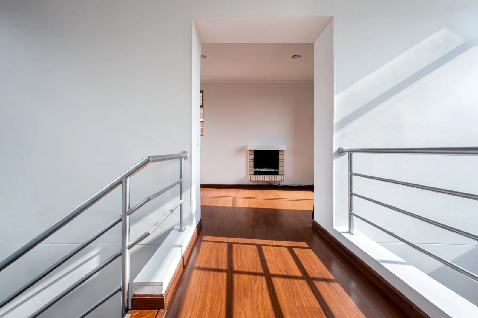 Laminate flooring running down a bright minimalist hallway